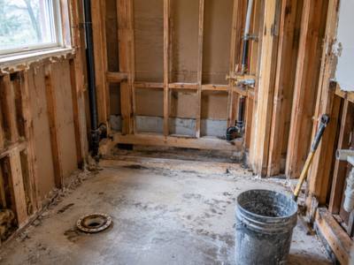 Bathroom stripped to the studs with the tub removed